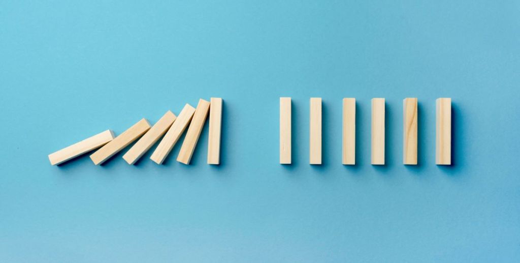 small wooden blocks on a blue background, failing first, then standing